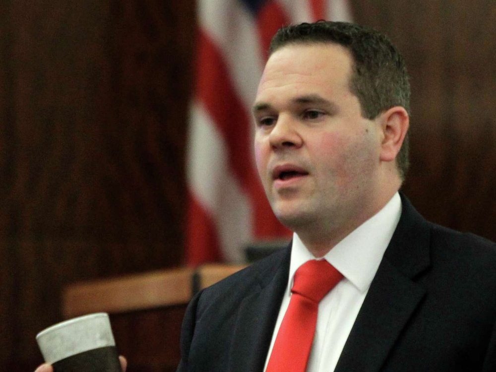 Justin Keiter holding a coffee cup exhibit while presenting evidence to the jury